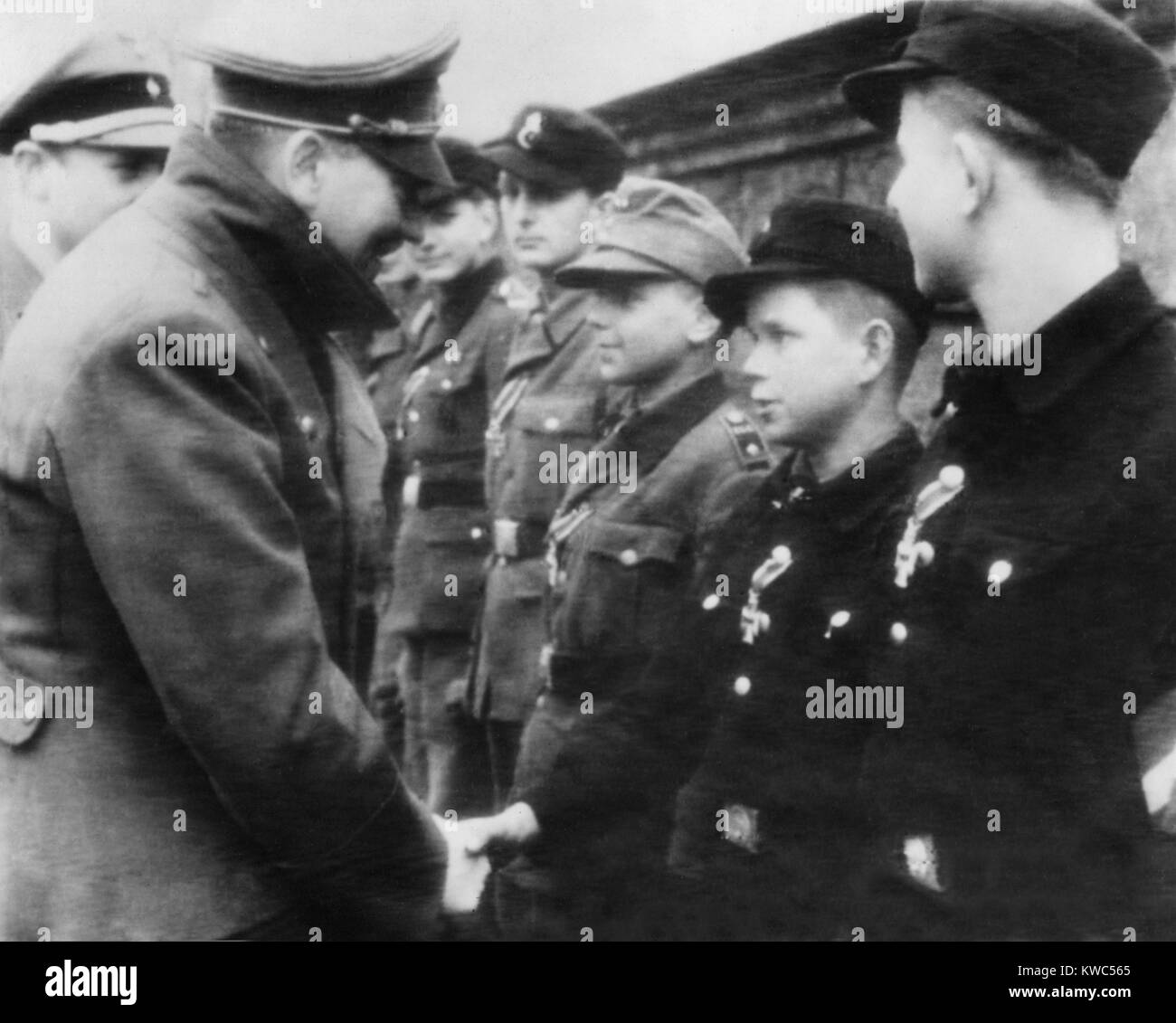 Hitler schmückt ein 12-jähriger Junge Soldat mit dem Eisernen Kreuz zweiter Klasse. Das Foto wurde in der Nähe von Hitlers Bunker Hauptsitz in der letzten Schlacht von Berlin gegen die sowjetischen Armeen. Weltkrieg 2, April 1945. (BSLOC 2015 13 76) Stockfoto