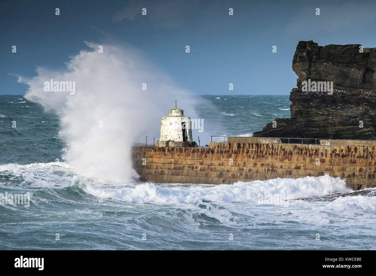 UK Wetter - Gale force Winde fahren riesige Wellen in die Pier in Portreath Hafen in Cornwall. Stockfoto