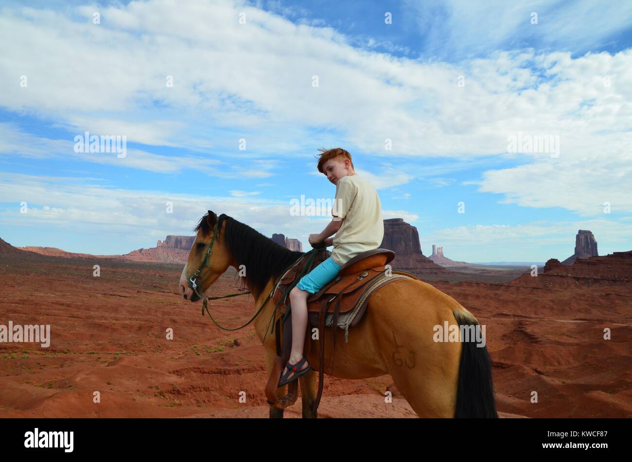 Rothaarige junge auf Reiten im Monument Valley in Shorts Stockfoto