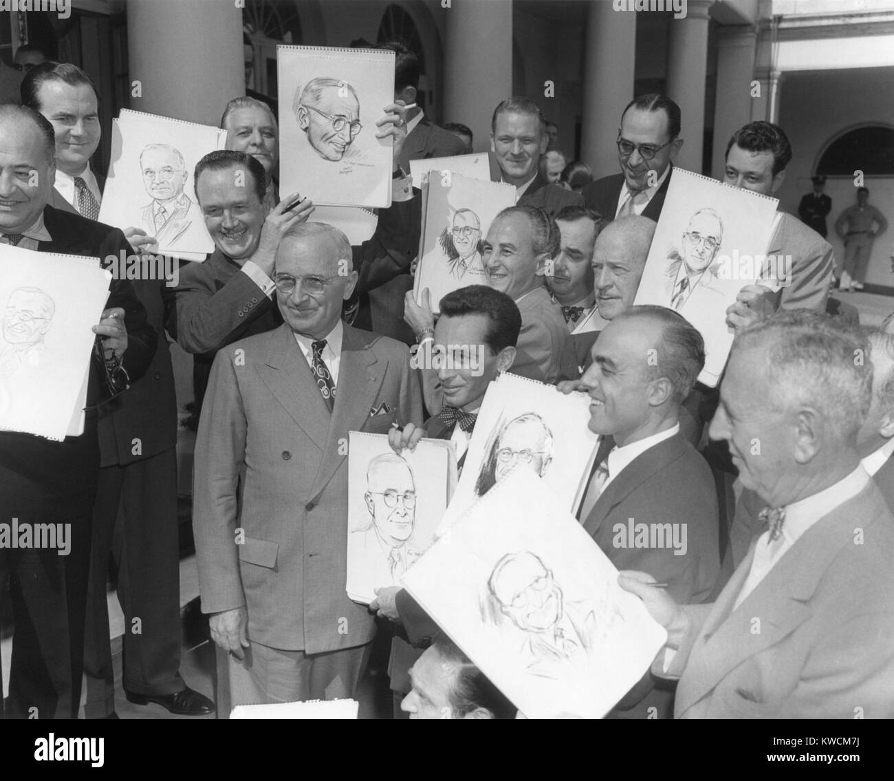 Präsident Harry Truman posiert im Weißen Haus mit Besuch Karikaturisten. Oktober 3, 1949. Karikaturist identifiziert, Zeichnungen, L-R: Schinken Fisher (teilweise abgeschnitten), Milton Caniff, Alex Raymond, Jo Fischer (über trumans linke Schulter), Alfred Andriola (Bow Tie, neben Truman), Ray Van Buren (neben Fischer), John Pieretti, und Rube Goldberg (unten rechts). - (BSLOC 2014 14 31) Stockfoto