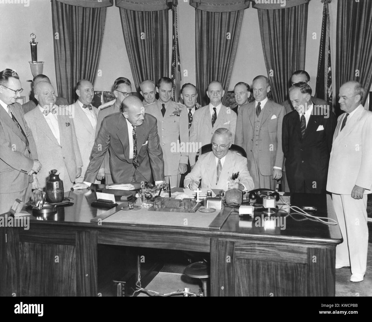 Präsident Harry Truman Unterzeichnung H.R. 5632, das National Security Act Änderungen von 1949. Das Gesetz der nationalen militärischen Establishment in eine neue Abteilung für Verteidigung. 10.08.1949. L bis R: Sen. Virgil Chapman; keine ID; Sen. Richard Russell; Adm. Louis Denfelt; Sen Leverett Saltonstall; Verteidigung Sec. Louis Johnson (schiefen über dem Schreibtisch); General Omar Bradley; Gen. Hoyt Vandenberg; Rep. Dewey Short; Rep. Carl Vinson; Armee Sec. Gordon Grau, Sen Millard Tydings, AF-Sec. Stuart Symington; unter Verteidigung Sec. Stephen Früh und Navy Sec. Francis Matthews. - (BSLOC 2014 15 68) Stockfoto