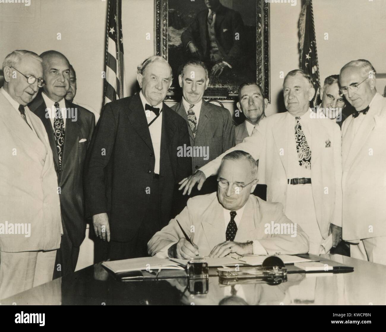 Präsident Harry Truman unterzeichnet die Atlantischen Pakt am 27. Juli 1949. Hinter Truman, stehend, L-R: Sen Walter George; Def. Sec. Louis Johnson; Sen. Tom Connally; Sek., Dean Acheson; VP Alben Barkley; Sen. Arthur Vandenberg. - (BSLOC 2014 15 72) Stockfoto