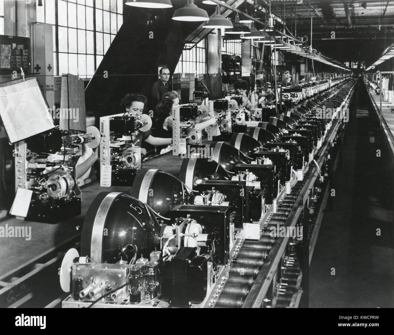 TV-Chassis auf einem Fließband mit ArbeiterInnen in einer US-Fabrik. Juli 1949. -(BSLOC 2014 17 137) Stockfoto