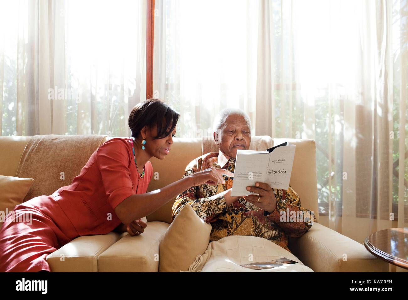 First Lady Michelle Obama trifft sich mit ehemaligen Präsidenten Nelson Mandela in Südafrika. An Mandelas in Houghton, Südafrika, 21. Juni 2011. Mandela hält ein Buch, 'Mandela, der autorisierte Buch der Zitate'. (BSLOC 2015 3 203) Stockfoto