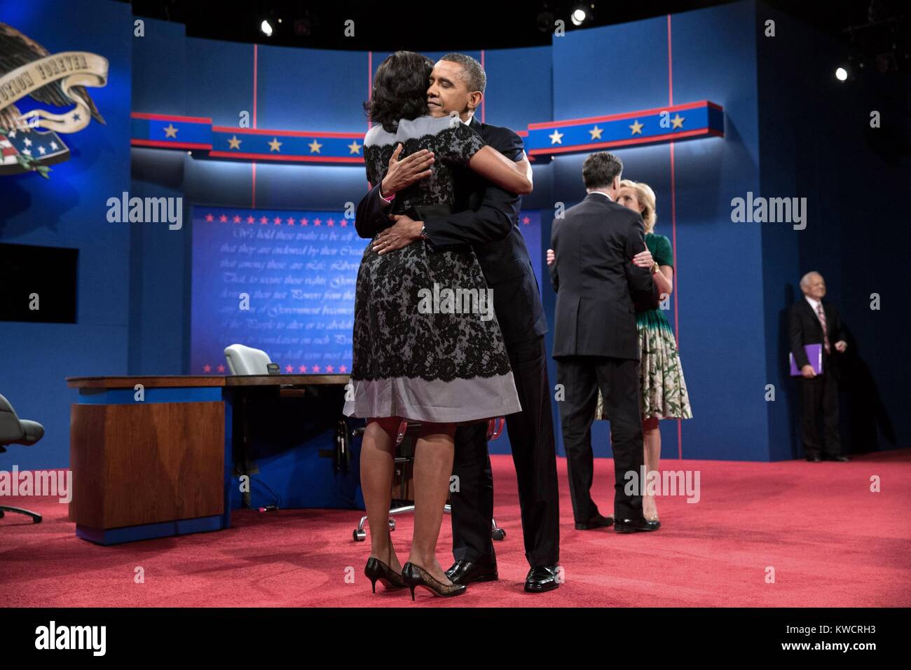 2012 Präsidentschafts Kandidaten werden von ihren Frauen nach dem dritten Präsidentendebatte umfasst. Okt. 22, 2012. Am Lynn University in Boca Raton, Florida, L-R: Michelle und Barack Obama; Mitt Romney; Aussprache und Anne moderator Bob Schieffer. (BSLOC 2015 3 27) Stockfoto