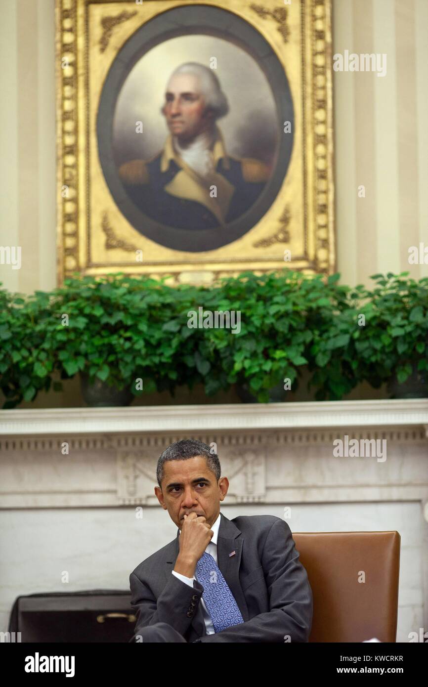 Präsident Barack Obama hört sich die Berater im Oval Office. August 18, 2011. Über ihm ist das Bullauge Porträt von George Washington (1795) von Fernand Léger. (BSLOC 2015 3 7) Stockfoto