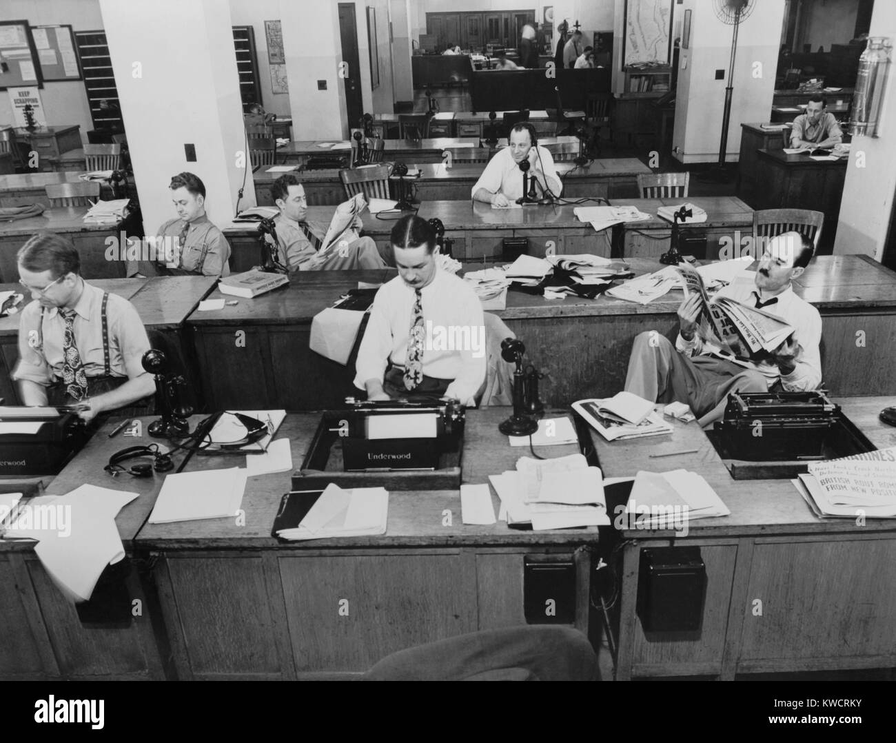 Newsroom der New York Times. Reporter und Rewrite Männer schreiben von Geschichten, während andere warten ausgesendet werden. Rewrite Mann im Hintergrund bekommt eine Geschichte am Telefon von Reporter außerhalb. September 1942. -(BSLOC 2015 1 185) Stockfoto