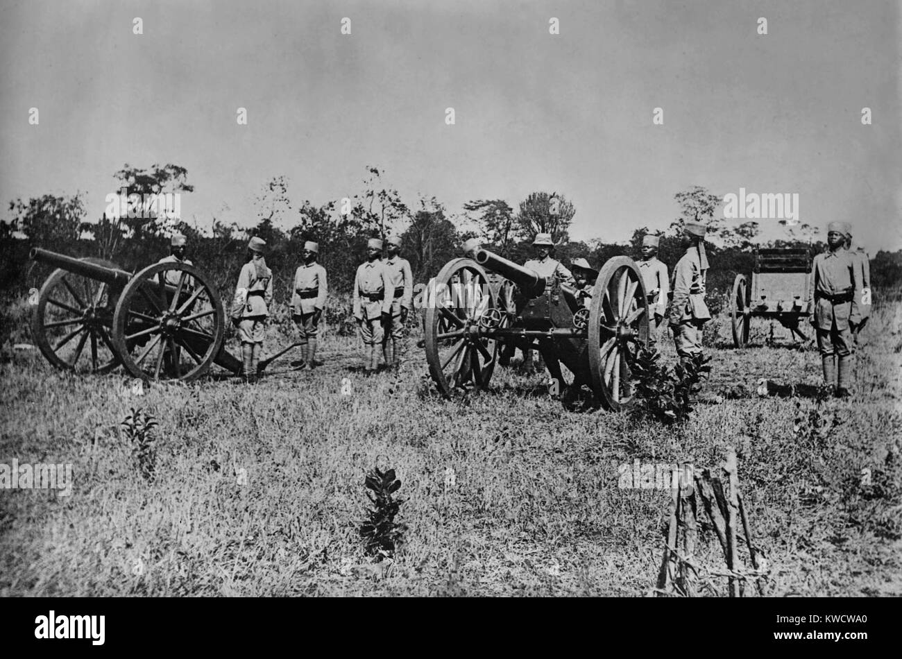 Der Erste Weltkrieg in Ostafrika. Deutschen Askaris (native Soldaten) an Aufmerksamkeit posiert mit Artillerie. Manning das Gewehr auf der linken Seite befinden sich zwei deutsche Offiziere. Ca. 1915-18. (BSLOC 2013 1 39) Stockfoto