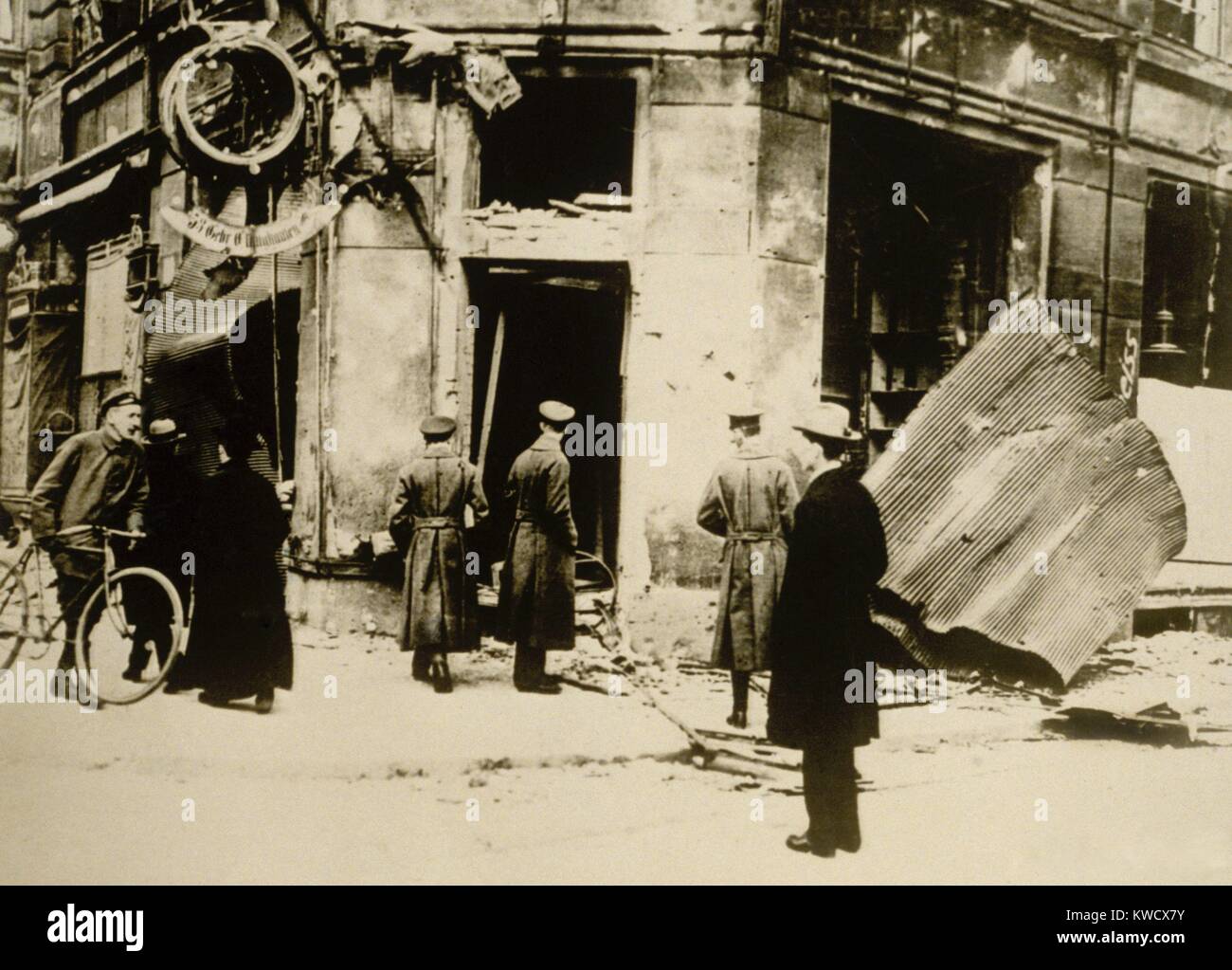 Deutsche Männer stehen vor einem zerstörten Polizei Station während der Hamburger Aufstand von Okt. 23, 1923. Kommunistischen Kämpfer angegriffen 17 Polizeistationen, Stahl, Waffen, festgehalten einige lokale Führer, und in der kurze Straße Kämpfe in der Sowjetischen 1 Tag Revolte. Über 100 Menschen starben während der 24 Stunden Aufstand (BSLOC 2017 2 67) Stockfoto