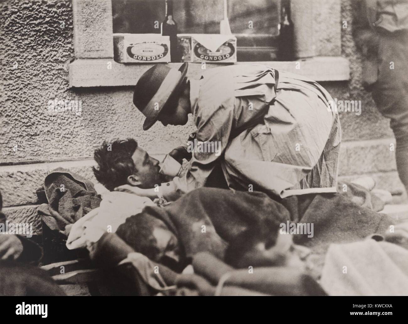 Das amerikanische rote Kreuz Krankenschwester Hilfe für verwundete Soldaten in Montmirail, Frankreich, 31. Mai 1918. Sie hilft ein Soldat aus einer Tasse trinken, wie er liegt auf einer Eisenbahn Plattform warten auf die Evakuierung (BSLOC 2017 1 15) Stockfoto