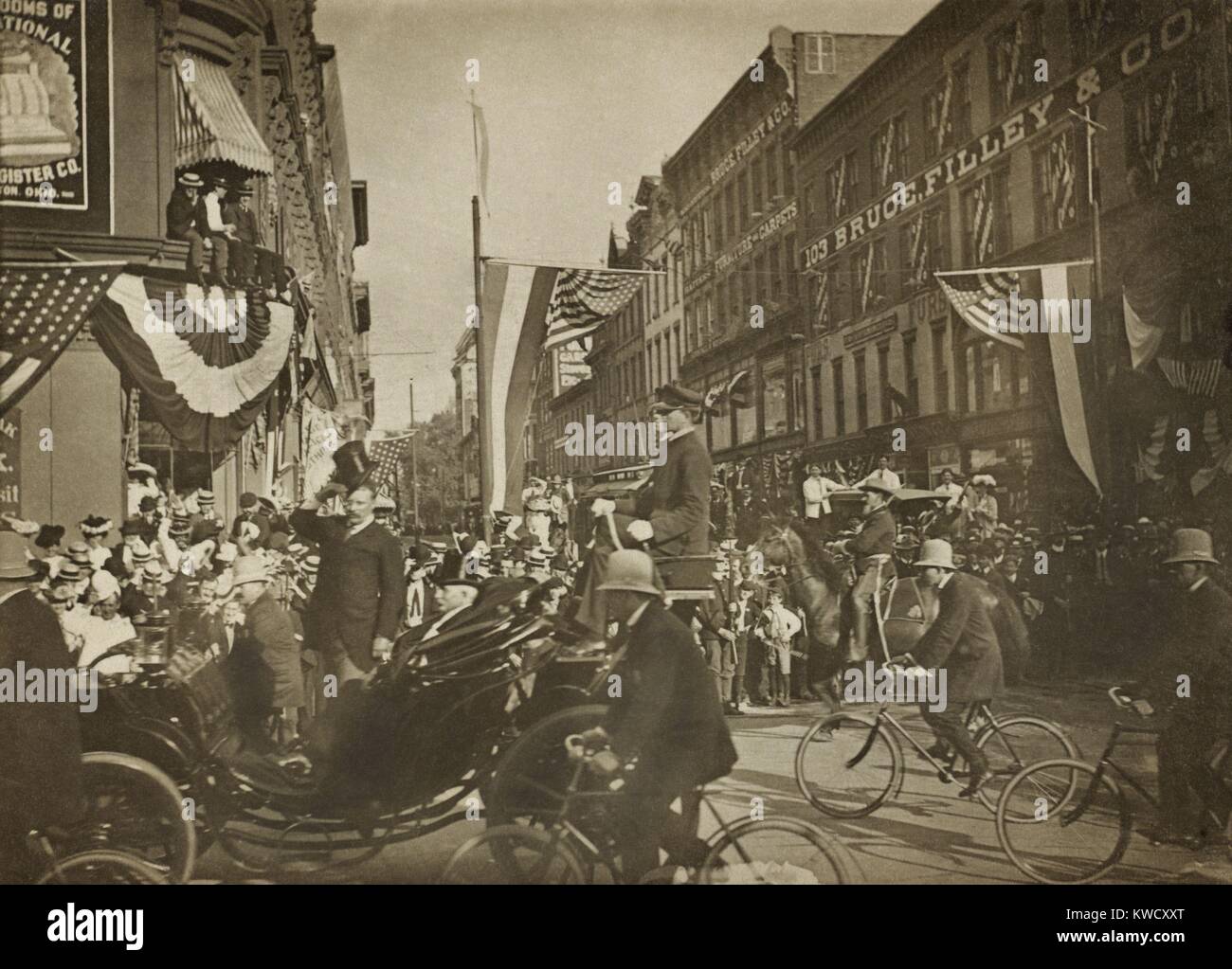 Theodore Roosevelt in einer Beförderung, Tipping seinen Hut, mit dem Fahrrad die Polizei im Jahr 1902 begleitet. Unbekannter Standort (BSLOC 2017 4 54) Stockfoto