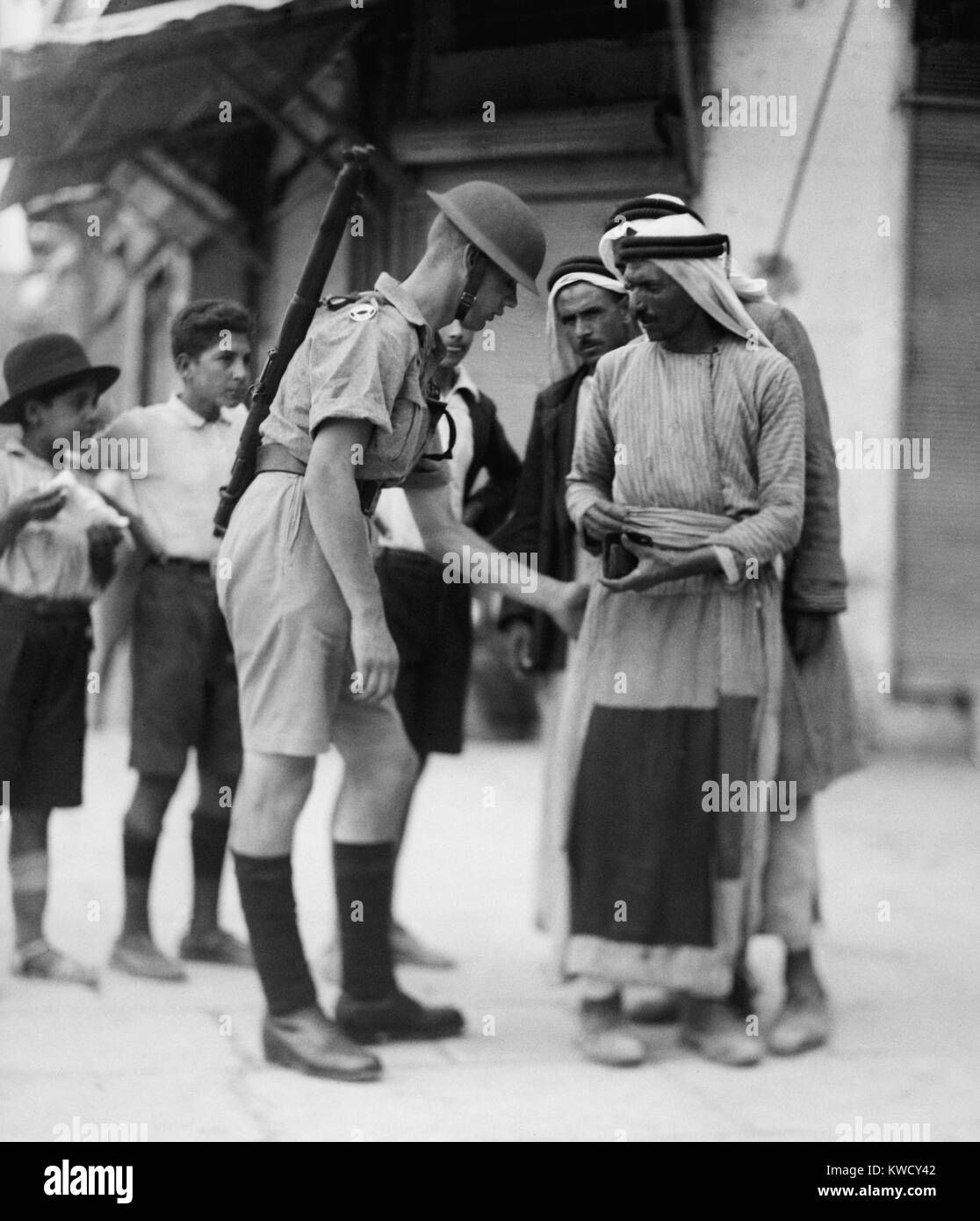 Britischer Soldat Kontrolle Papiere und Suche Araber für Arme an den Jaffa, Jerusalem. 1936 Während des Arabischen Aufstands (BSLOC 2017 1 203) Stockfoto