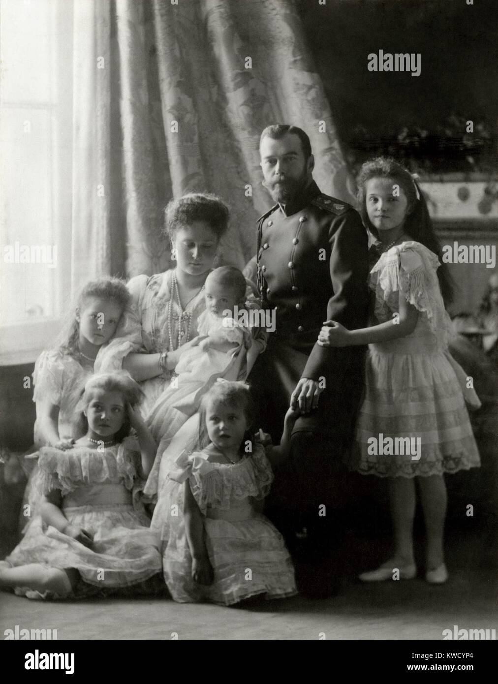 Nicholas II und Familie bei der Taufe von Czarevich Alexei, 1904. Im Uhrzeigersinn von Zar Nicolas sind Großfürstinnen Olga, Anastasia, Maria, Tatiana, Zarin Alix von Hessen mit ihrem Sohn (BSLOC 2017 2 2 8) Stockfoto