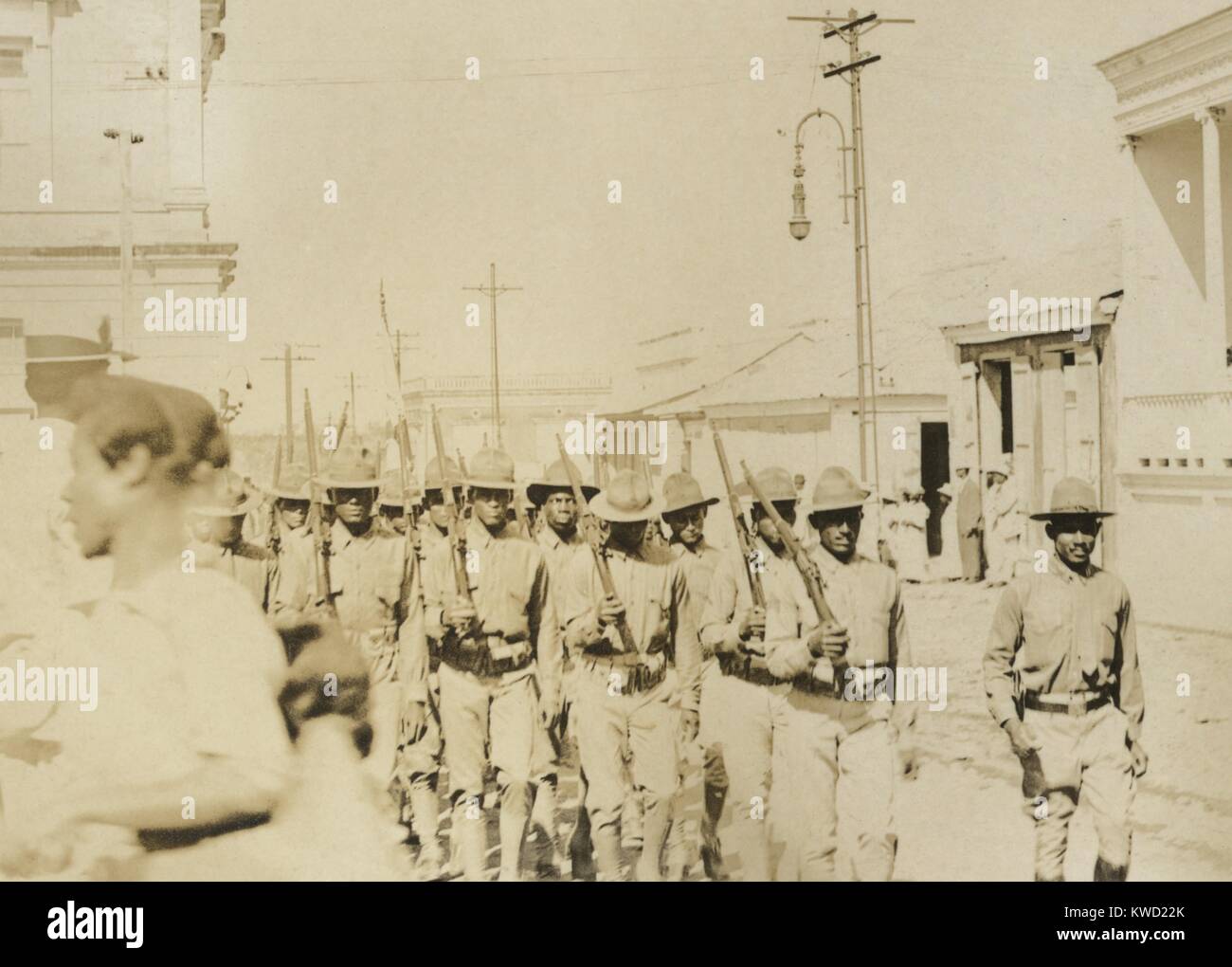 Afrikanische amerikanische Soldaten marschieren Straße die Springfield Rifles, C. 1903. Die Lage der Parade ist unbekannt. Das Dienstprogramm Linien zeigen eine wohlhabende Stadt, die möglicherweise in den westlichen Vereinigten Staaten (BSLOC 2017 20 105) Stockfoto