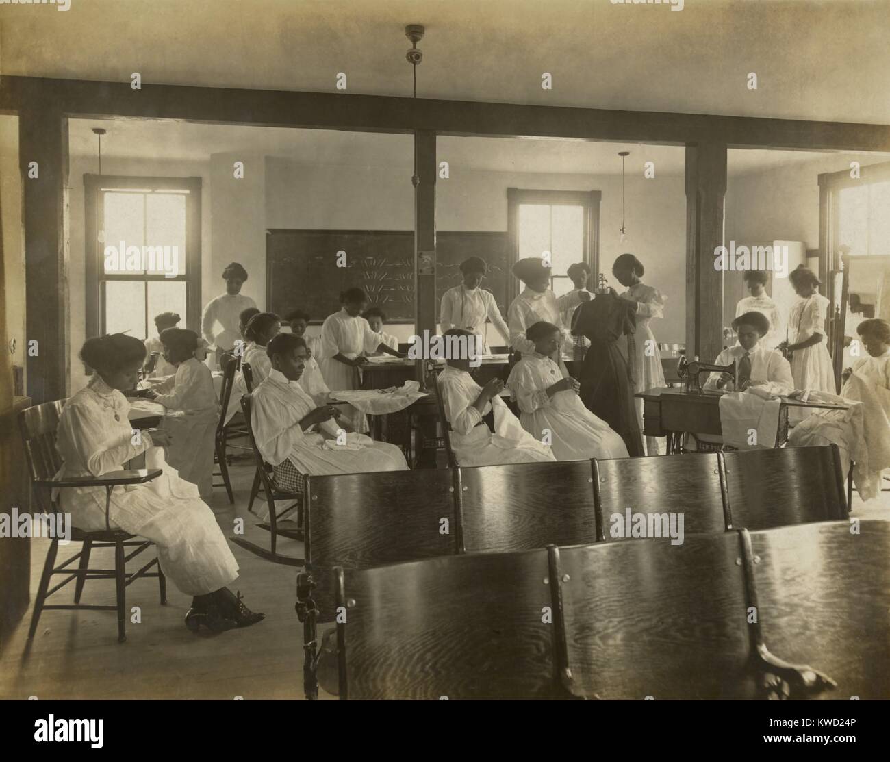 Afro-amerikanische Frauen nähen von Hand und mit der Nähmaschine im Klassenzimmer, C. 1911-18. Nannie Helen Burroughs gründete die Nationale Schule für Frauen und Mädchen, in Washington, D.C., als schwarze Frauen für qualifizierte häusliche Arbeit zu trainieren (BSLOC 2017 20 142) Stockfoto