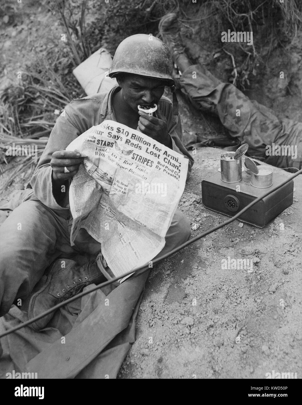 African American radio Operator liest Nachrichten beim Essen Rationen in der Nähe von Sangju, Korea. August 9, 1950. Koreakrieg, 1950-1953. (BSLOC 2014 11 147) Stockfoto