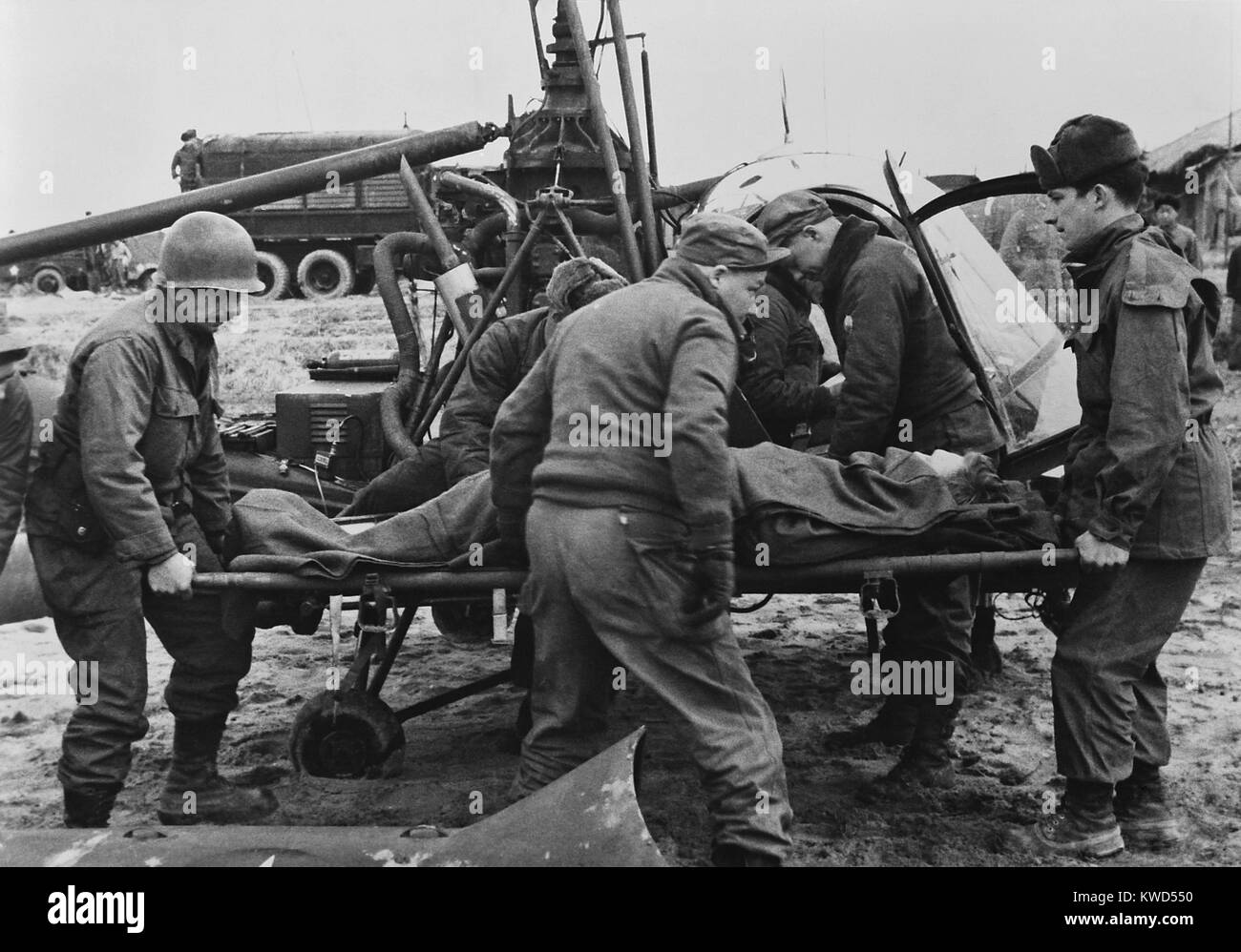 Ärzte tragen eine verletzte US-Soldat von einem Rettungshubschrauber. Sein nächster Halt die mobile der Chirurgischen Klinik zu einem fünften Luftwaffe fighter Streifen werden nur eine kurze Entfernung von der Schlacht Linien koreanischen Krieges, 1950-1953. (BSLOC 2014 11 193) Stockfoto