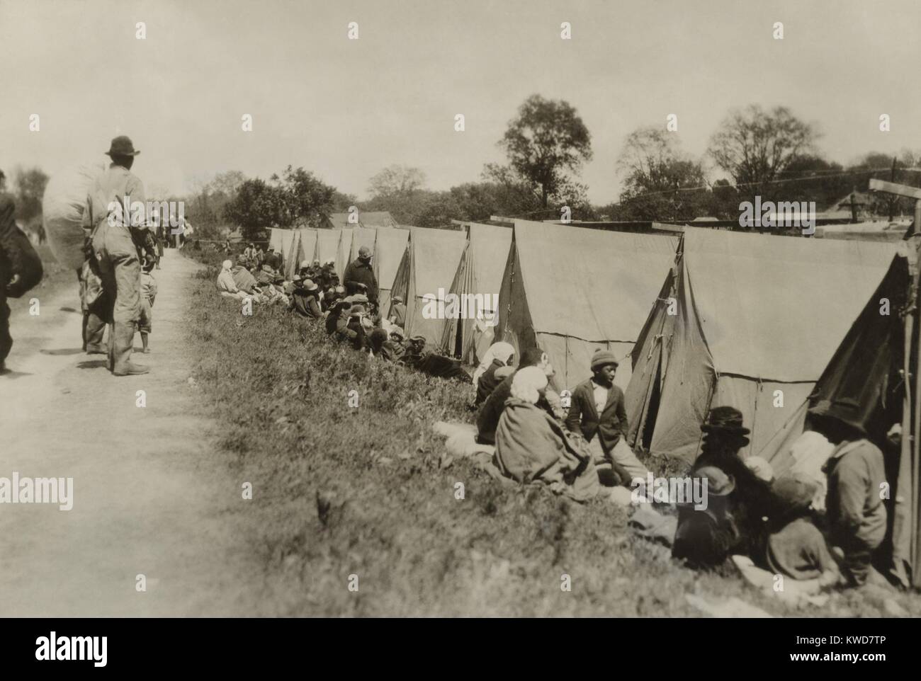 Deich in Greenville, Mississippi, in dem afrikanische Amerikaner von Zelten auf unebenem Boden sitzen. Die Zelte wurden durch das Amerikanische Rote Kreuz versorgt. Mit keine etablierten Emergency Response Force, der US-Kongress gechartert, das Rote Kreuz, die Katastrophenhilfe, die durch Spenden finanziert wurde. (BSLOC 2015 16 165) Stockfoto