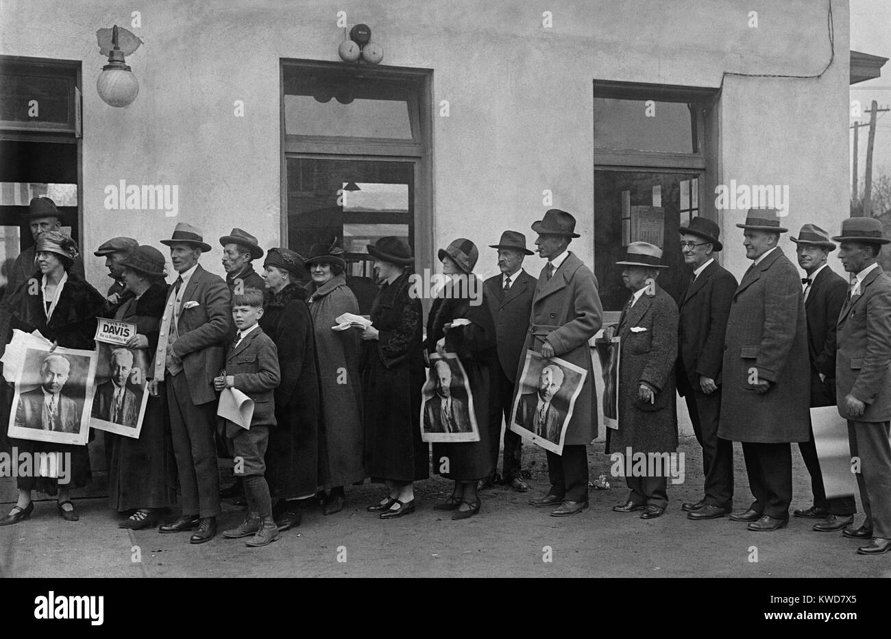Männer und Frauen in der Warteschlange bei der Clarendon, Virginia, November 4, 1924 zu stimmen. Einige Leute halten Plakate für Demokratische Präsidentschaftskandidat, John Davis. (BSLOC 2015 16 191) Stockfoto
