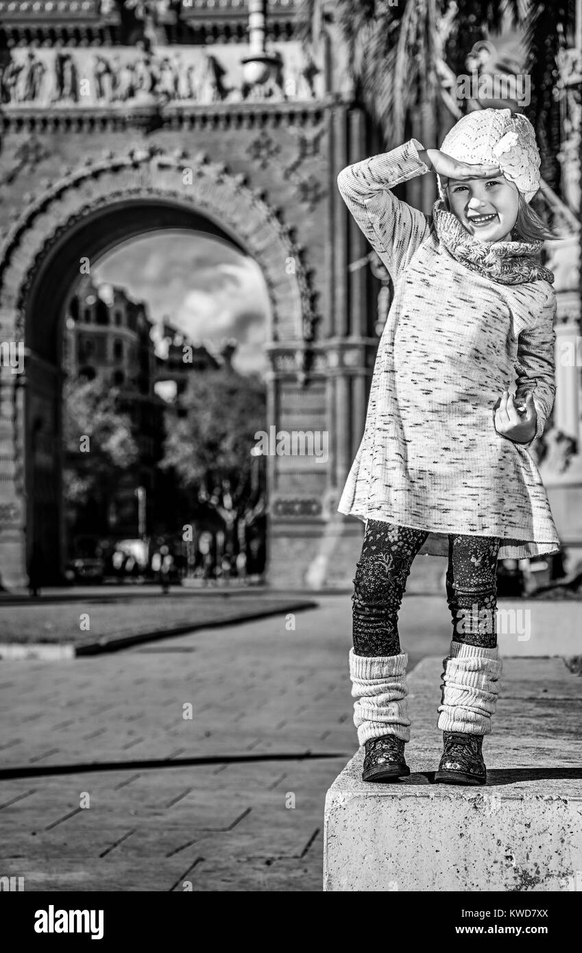 in Barcelona für einen perfekten Winter. In voller Länge Portrait von glücklich trendige Mädchen in der Nähe von Arc de Triomf in Barcelona, Spanien, Blick in die Ferne Stockfoto