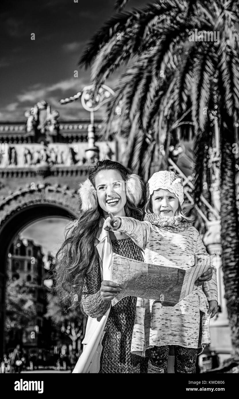 in Barcelona für einen perfekten Winter. Porträt von glücklich moderne Mutter und Kind in der Nähe von Arc de Triomf in Barcelona, Spanien im Besitz Karte und zeigt Stockfoto