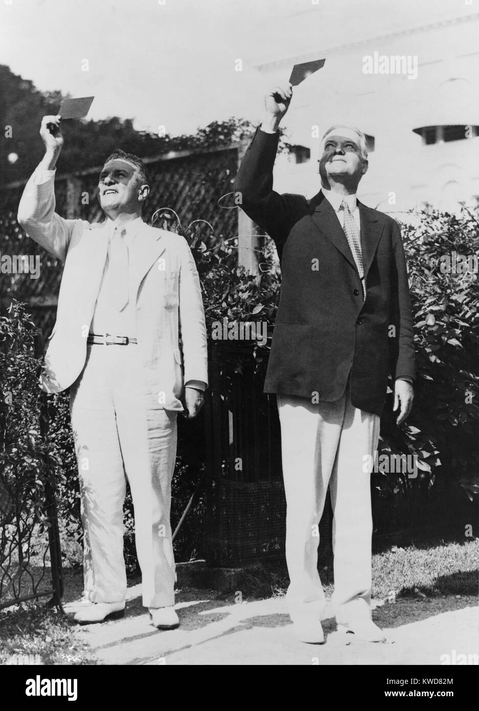 Präsident Herbert Hoover und Lawrence Richey Beobachtung einer Sonnenfinsternis durch getöntes Glas. August 31, 1932. Richey war Hoover Sekretärin, eine Position, die jetzt als "Stabschef im Weißen Haus." (BSLOC 2015 16 53) Stockfoto