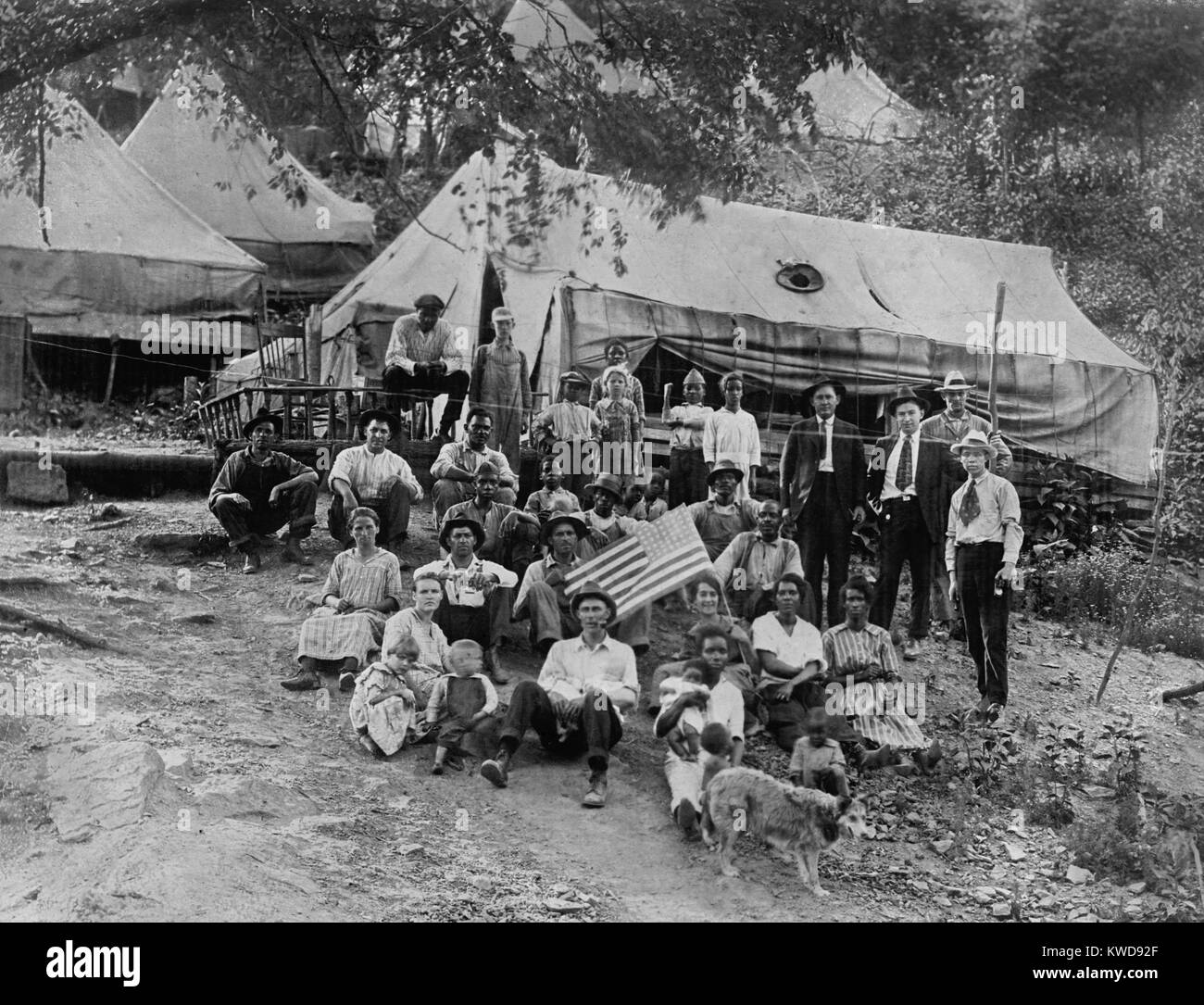 Markante union Bergarbeiter und ihre Familien leben in Zelten, lecken Creek, West Virginia, 12. April 1922. Schwarze und weiße Stürmer wurden von ihren Unternehmen Häuser geräumt und zog in Kohle lagern, die von der Union unterstützt. Hält eine Frau eine amerikanische Flagge (BSLOC 2016 8 43) Stockfoto Markante union Bergarbeiter und ihre Familien leben in Zelten, lecken Creek, West Virginia, 12. April 1922. Schwarze und weiße Stürmer wurden von ihren Unternehmen Häuser geräumt und zog in Kohle lagern, die von der Union unterstützt. Hält eine Frau eine amerikanische Flagge (BSLOC 2016 8 43) Stockfoto