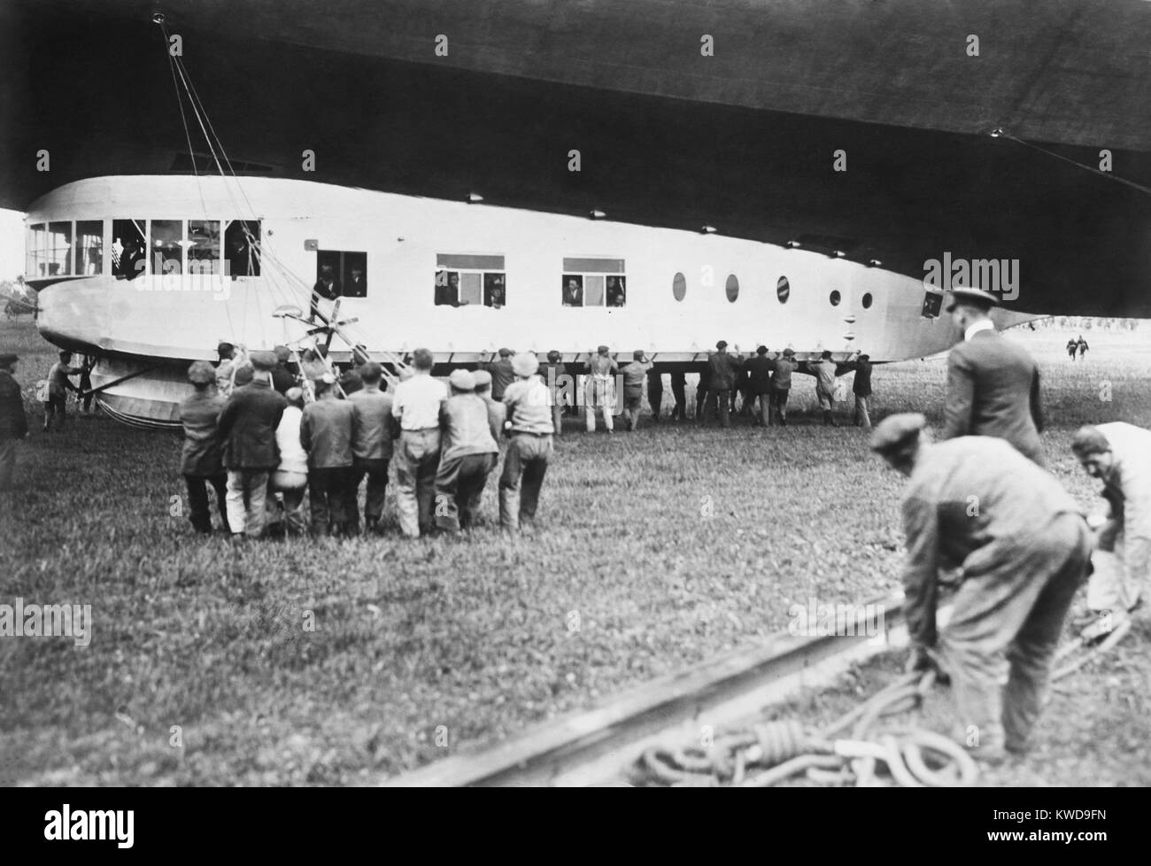 Kabine der "USS Los Angeles" während Ihrer Inbetriebnahme Zeremonie, an November 25, 1924. VIP-Passagiere sind innerhalb des "Gondel" als Bodencrew die Seile verarbeitet. Die zuvor benannten ZR-3, das lenkbare Luftschiff wurde im Jahr 1923 erbaut - 1924 von der Deutschen Zeppelin als Weltkrieg 1 Wiedergutmachung in die USA (BSLOC 2016 10 171) Stockfoto