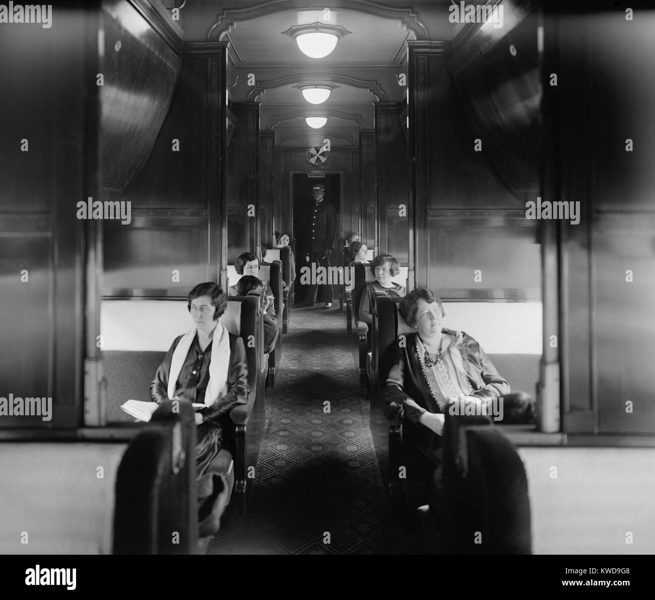 Passagiere und einen afrikanischen amerikanischen Porter in Pullman Auto auf der Southern Railway in den 1920er Jahren. Pullman Schlafwagen Tarife kosten mehr als Karten in einem "Coach" oder "Stuhl Auto'. Der Portier nahm an der "ersten Klasse" Passagiere und konvertiert den Tag Sitz, Schlafplätze in der Nacht (BSLOC 2016 10 177) Stockfoto