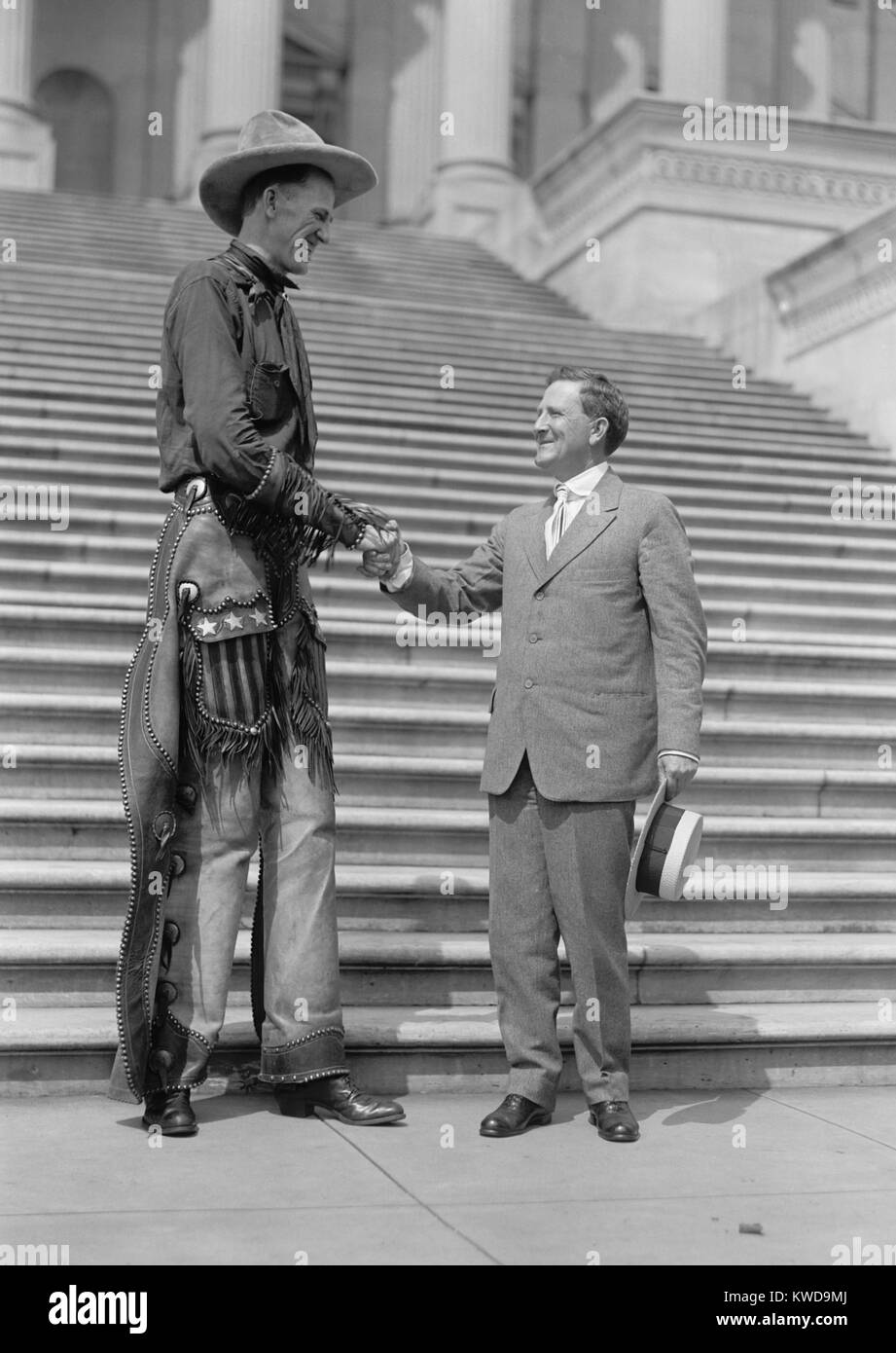 Ralph E. Madsen, die hohen Cowboy, Hände schütteln mit Sen Morris Sheppard, 1919. Die Nebraska geboren Madsen 7 Fuß 6 Zoll hoch war. Texas Senator Morris serviert von 1917-1941, und führte der Senat die Auflösung für den Achtzehnten Verfassungszusatz zur Gründung verbot. (BSLOC 2015 17 174) Stockfoto