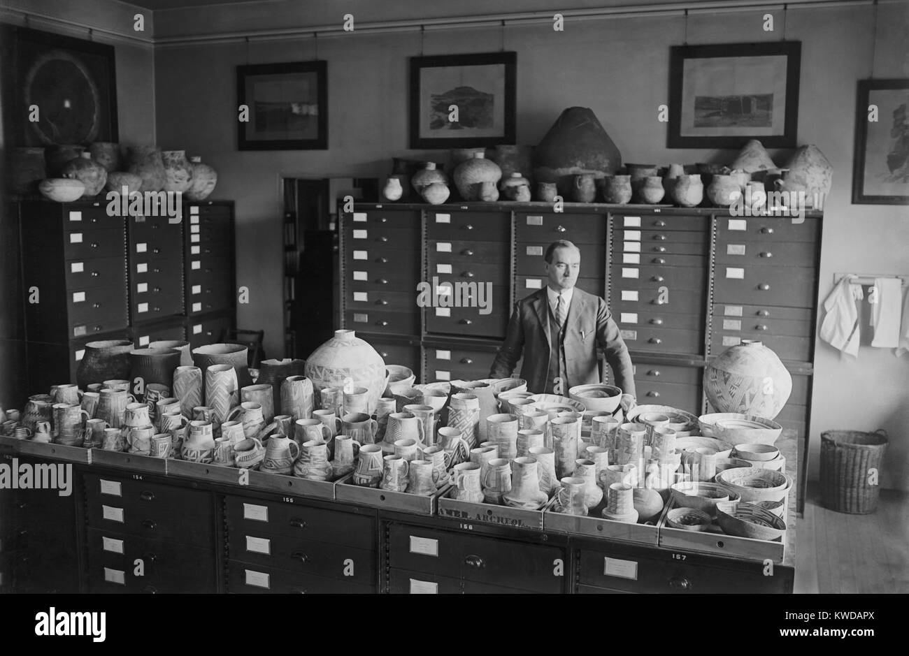 Neil Merton Judd stehend mit Native American Töpferei an der Smithsonian Institution, 1924. Er leitete das erste staatlich finanziertes Grabungen im Chaco Canyon, Aushub die Ruinen von Pueblo Bonito und Pueblo Del Arroyo (BSLOC 2016 10 24) Stockfoto