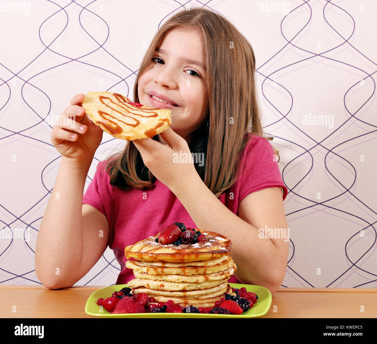 Kleines Mädchen hungrig essen süß panckaces Stockfoto