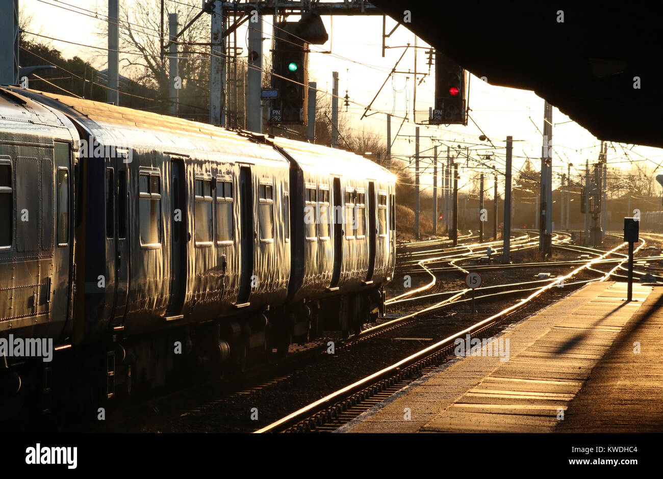 Klasse 150 Diesel Multiple Unit verlassen Carnforth Bahnhof mit späten Nachmittag Sonne Ausschalten blinkt die Schienen und der Wagen. Stockfoto