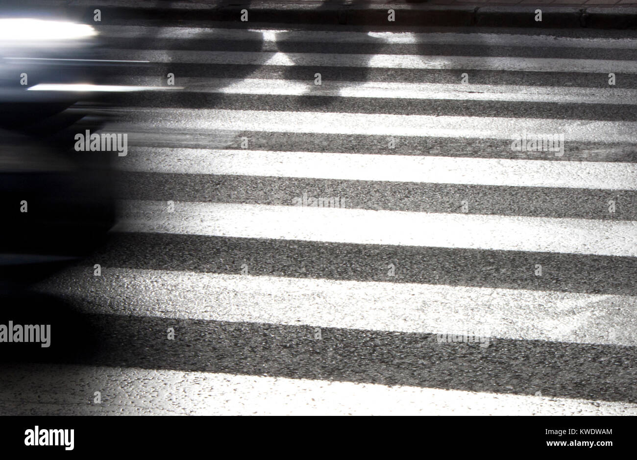 Defokussierten Schatten von Fußgängern auf der Straße von Zebra Zebrastreifen überqueren und fahren Auto, in Schwarz und Weiß Stockfoto