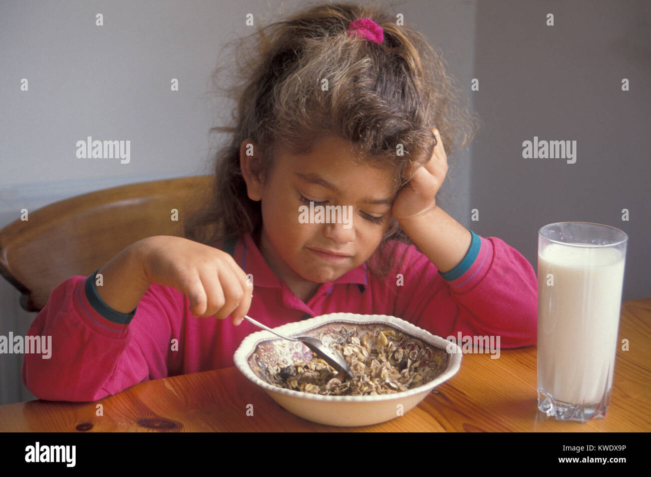 Kleine Mädchen die Nase drehen beim Frühstück mit Müsli Stockfoto