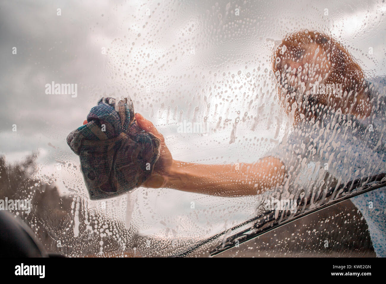 schöne Frau waschen Auto Windschutzscheibe, Stock Bild