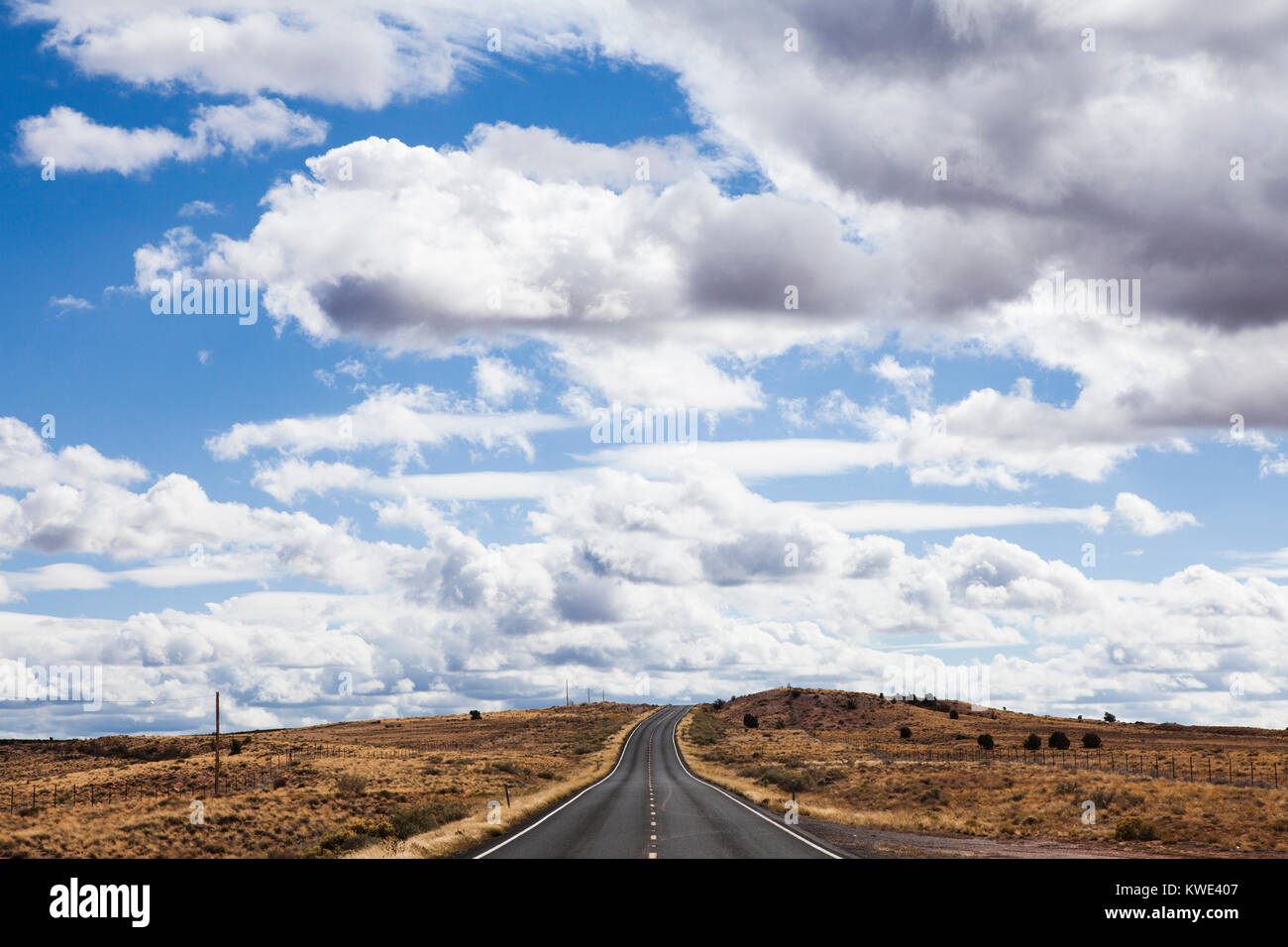 Hohe Betrachtungswinkel von Country Road inmitten von Feld gegen bewölkter Himmel Stockfoto