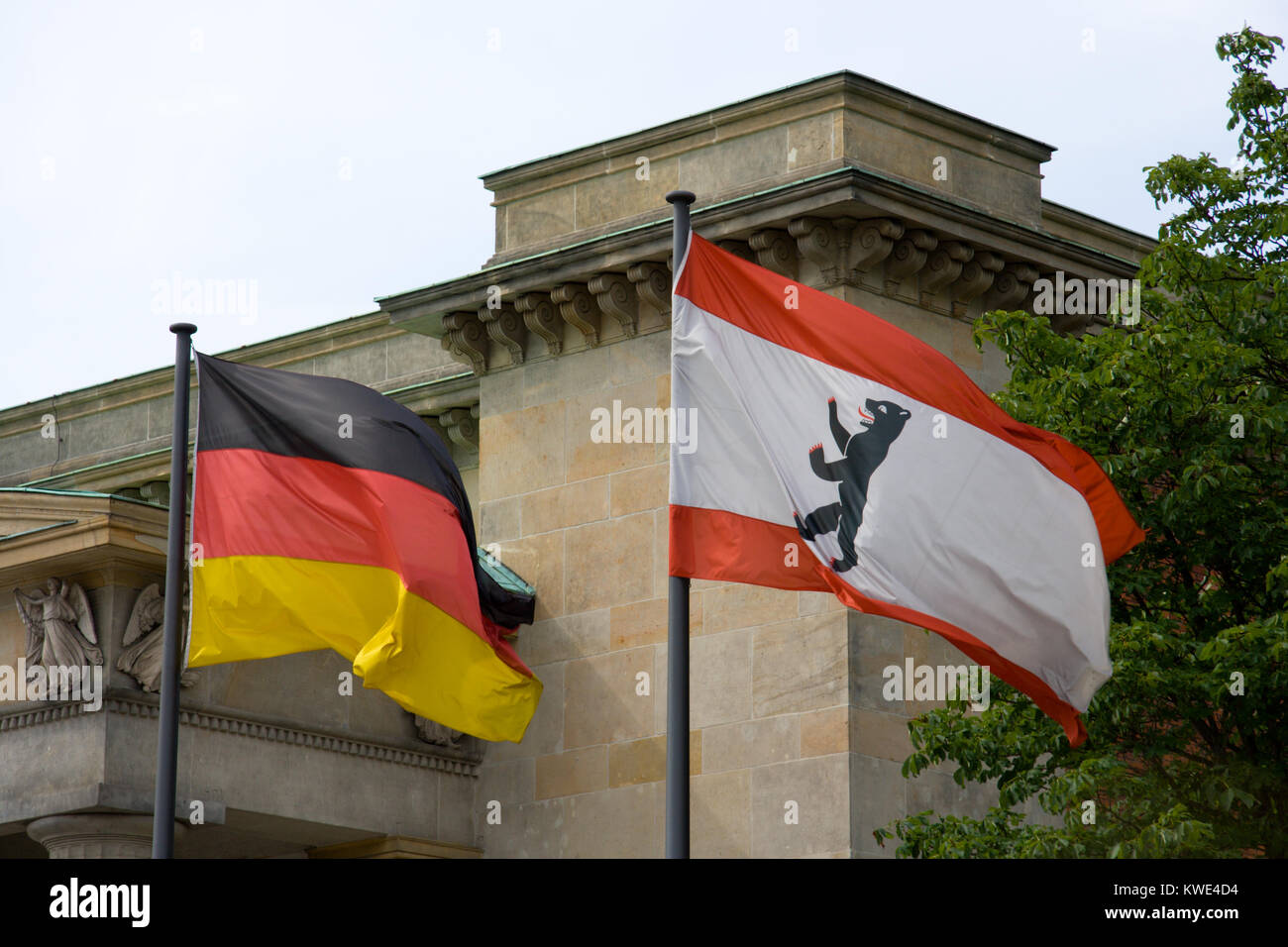 Flaggen von Deutschland und der Stadt Berlin vor einem alten Gebäude. Stockfoto