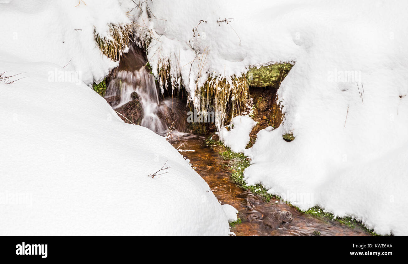 Winter Berglandschaft bedeckt mit Schnee leuchtet durch die untergehende Sonne Stockfoto