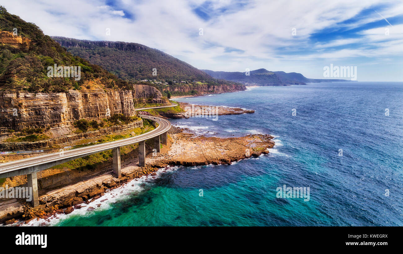 Luftbild des berühmten Sea Cliff Bridge auf dem Grand Pacific Drive in NSW, Australien. Scenic Highway am Rande der Sandsteinfelsen über tiding Surfen wav Stockfoto