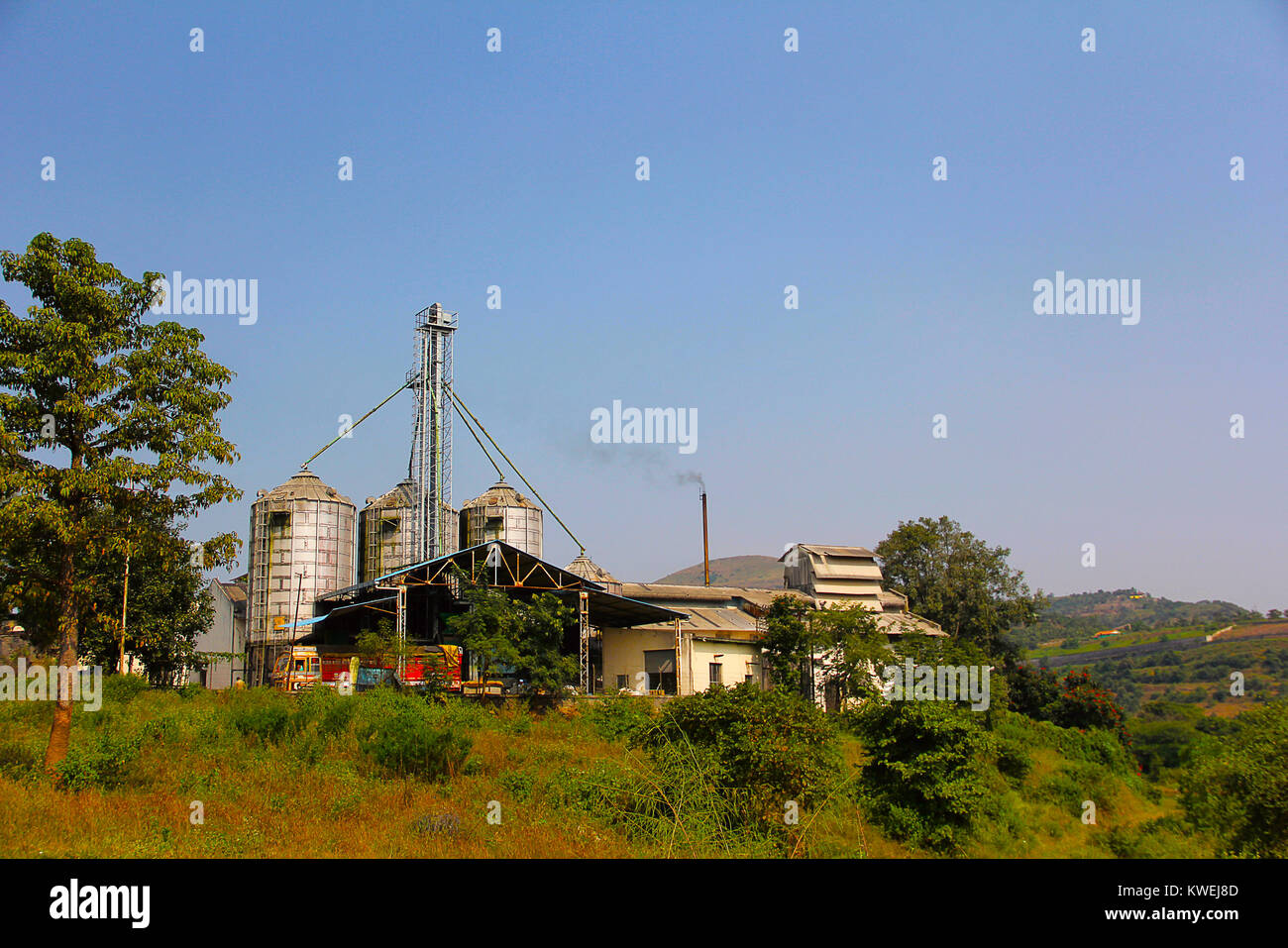 Kleinen industriellen Fabrik, rauchende Schornsteine durch die Natur und die Berge in der Nähe von Panshet, Pune umgeben Stockfoto