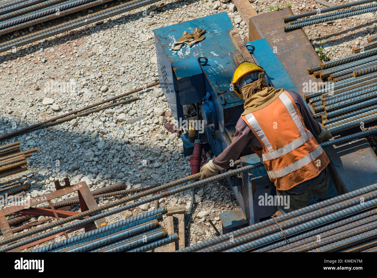 Ein Arbeitnehmer, der an einer Baustelle mit einer Stange aus Stahl Schneidemaschine Stockfoto