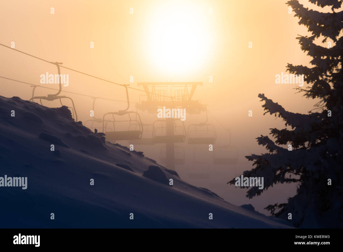 Stuhl Skilift mit Skifahrer sillhouettes bei Sonnenuntergang Stockfoto