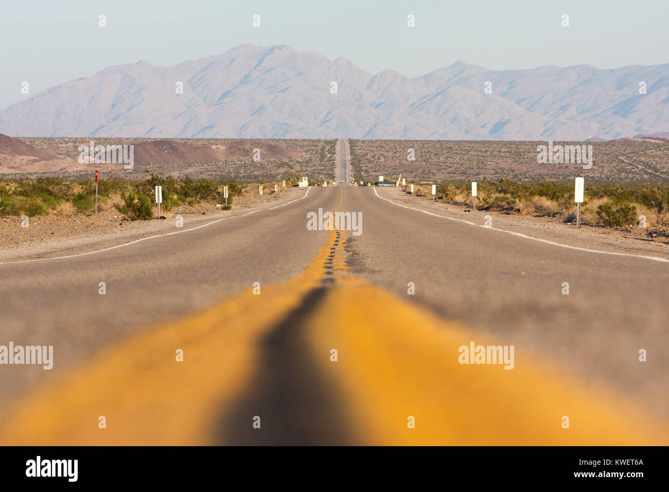 Klassische horizontale Panorama blick auf eine endlose gerade Straße laufen durch die karge Landschaft des amerikanischen Südwestens an einem schönen Tag Stockfoto