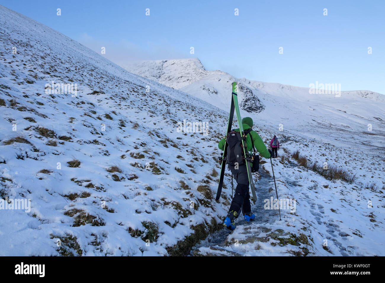 Skifahrer mit Skitouren Ausrüstung Wandern entlang der Glendermackin Pfad mit der scharfen Kante voran in Winter, Blencathra, Lake District, Cumbria, UK. Stockfoto