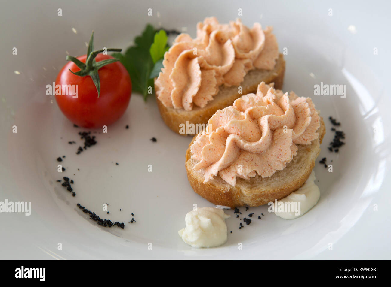 Tomaten und Sahne garniert Brot für das Abendessen in Maribor, Slowenien serviert. Der Teller ist ein Amuse Bouche. Stockfoto