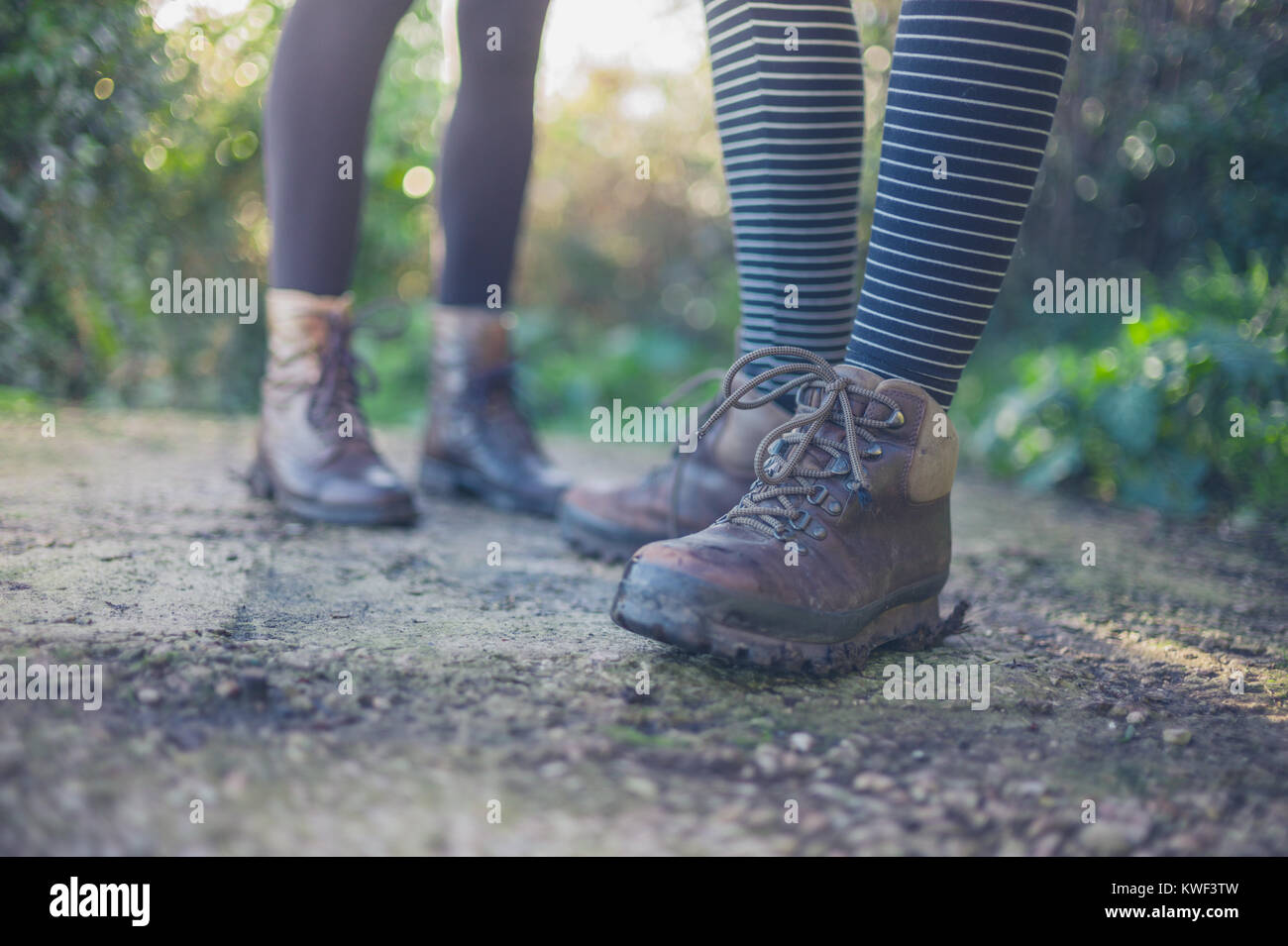 Die Schuhe und Füße von zwei jungen Frauen, die draußen in der Natur Stockfoto