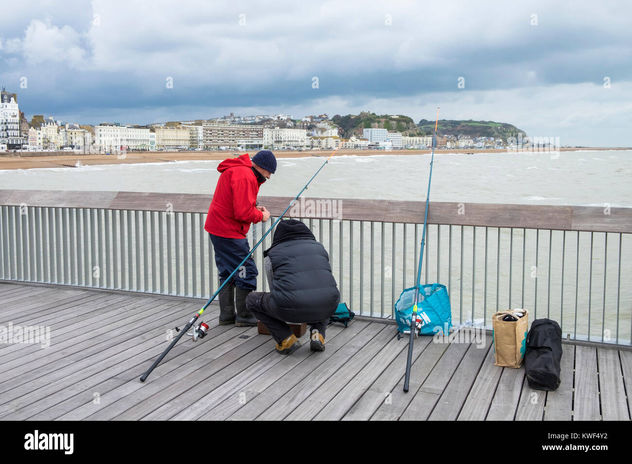 Männer angeln aus dem Hastings Pier in East Sussex Stockfoto