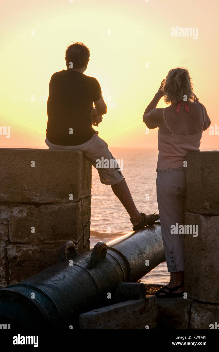 Paar auf Wälle beobachten den Sonnenuntergang in Essaouira, Marokko. Stockfoto