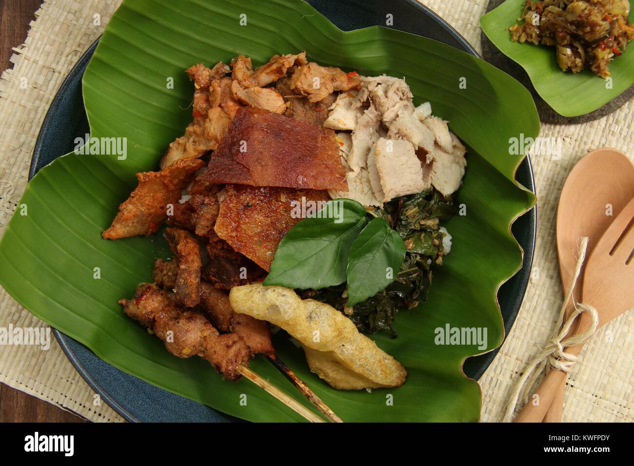 Nasi Campur babi guling. Balinesen Reis Reisgericht mit gedämpftem Reis garniert mit verschiedenen Gerichte der traditionellen Schweinebraten. Stockfoto
